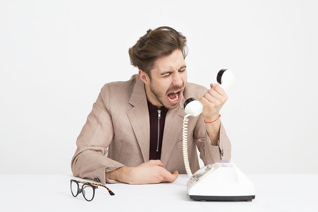 Mladý muž křičí do telefonního sluchátka